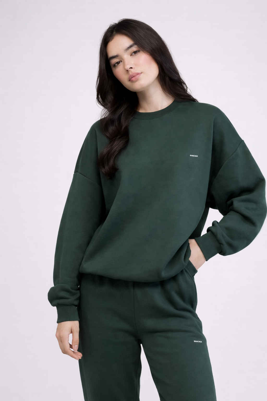 Ensemble sweat femme vert foncé en coton biologique porté en studio avec une posture calme et naturelle
