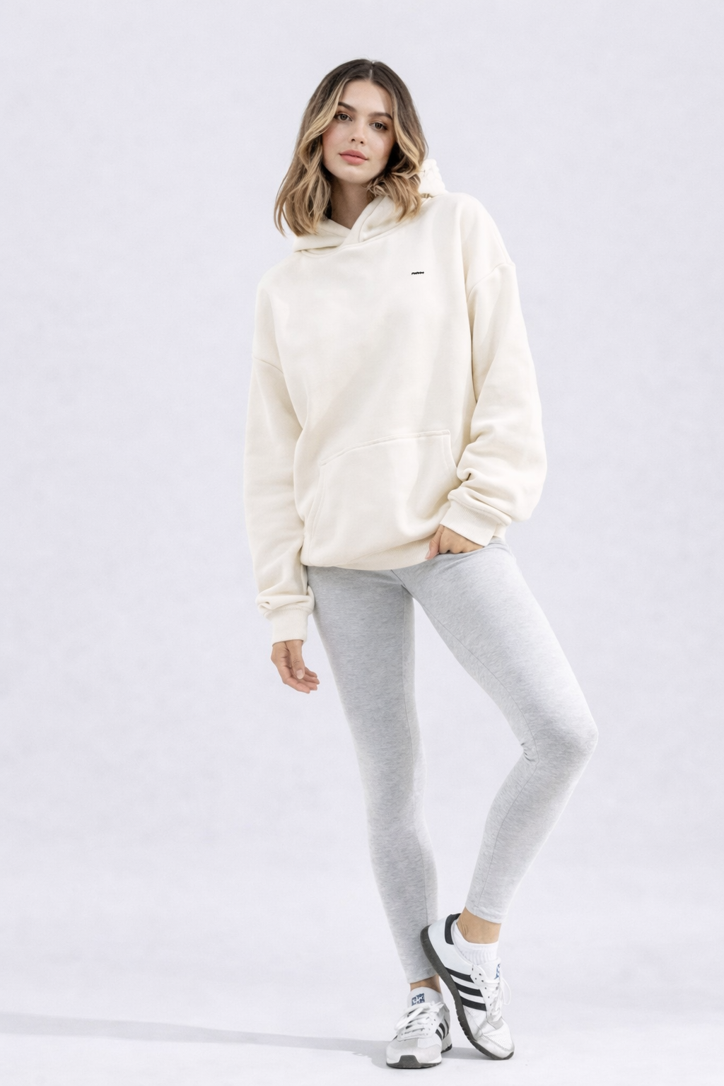 Hoodie femme écru en coton biologique porté en studio avec une silhouette douce et naturelle