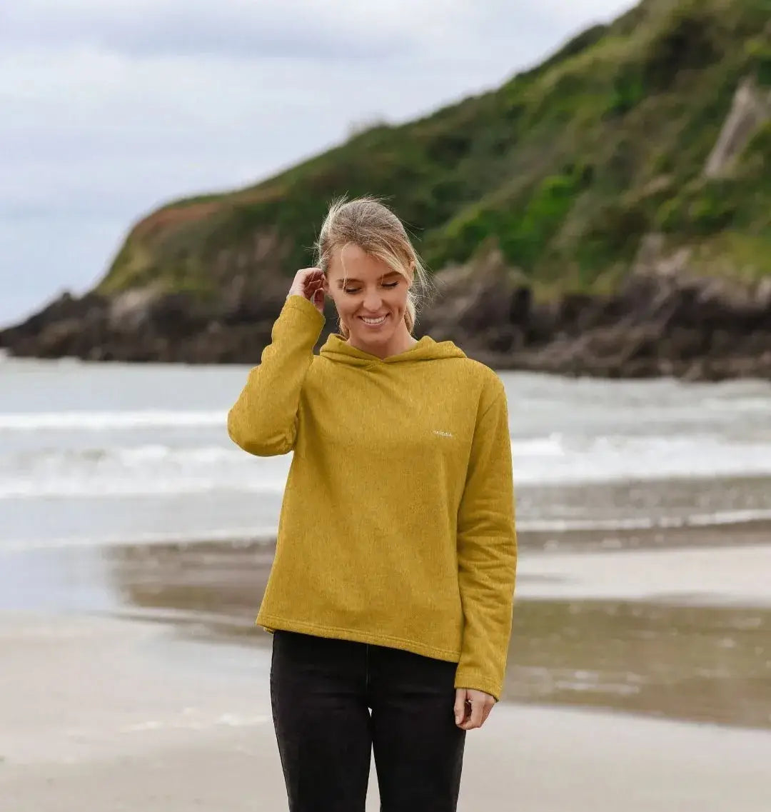 femme portant un sweat à capuche sable doré KARDAIA sur la plage, coupe décontractée